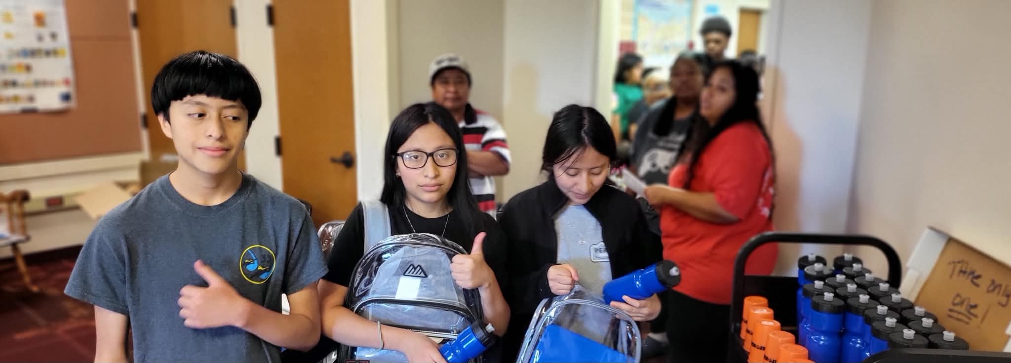 A crowded hallway filled with families and children during a Back to School community event.