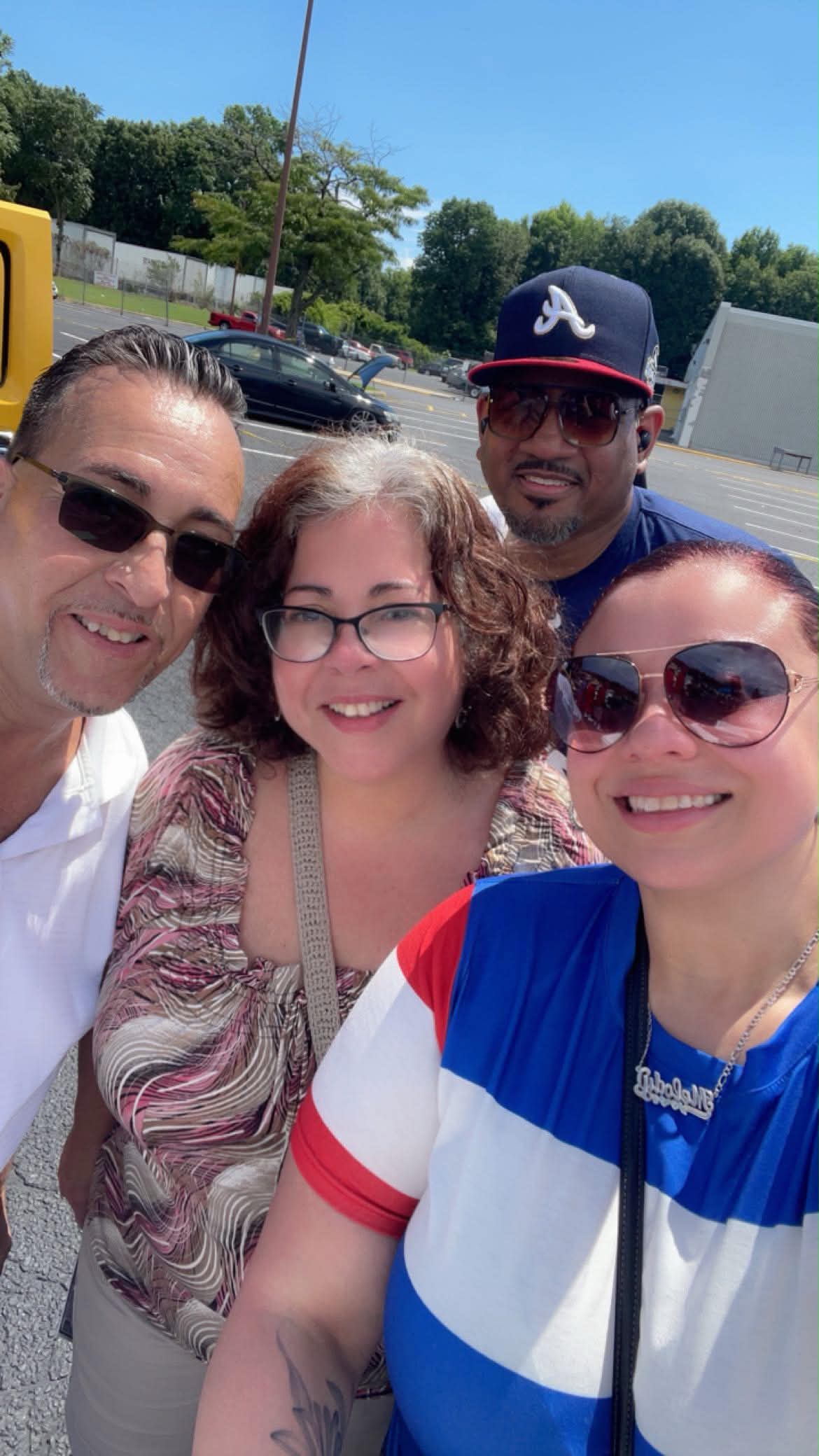 Four festival attendees smile for a selfie outdoors during the Puerto Rican Festival.