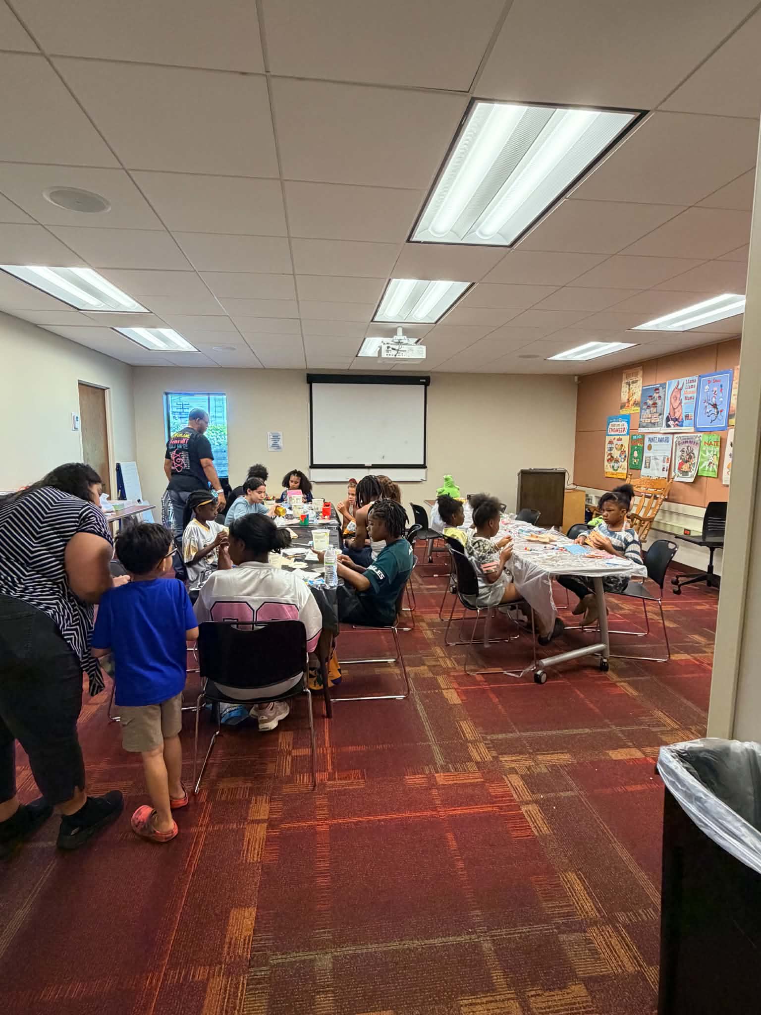 A wide view of participants and facilitators during a Rising Up Now art workshop.