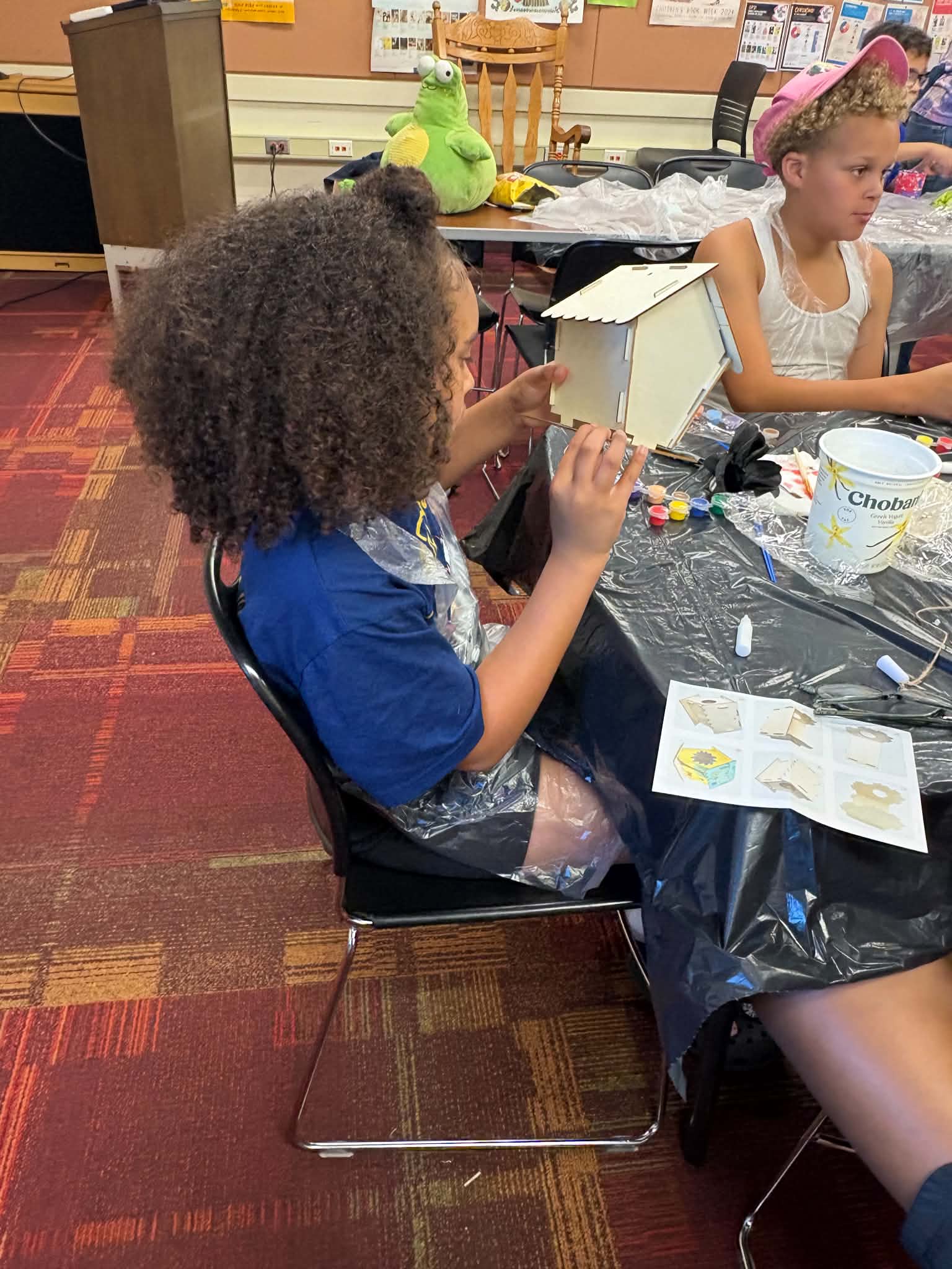 A participant painting while seated at a craft table during a workshop.