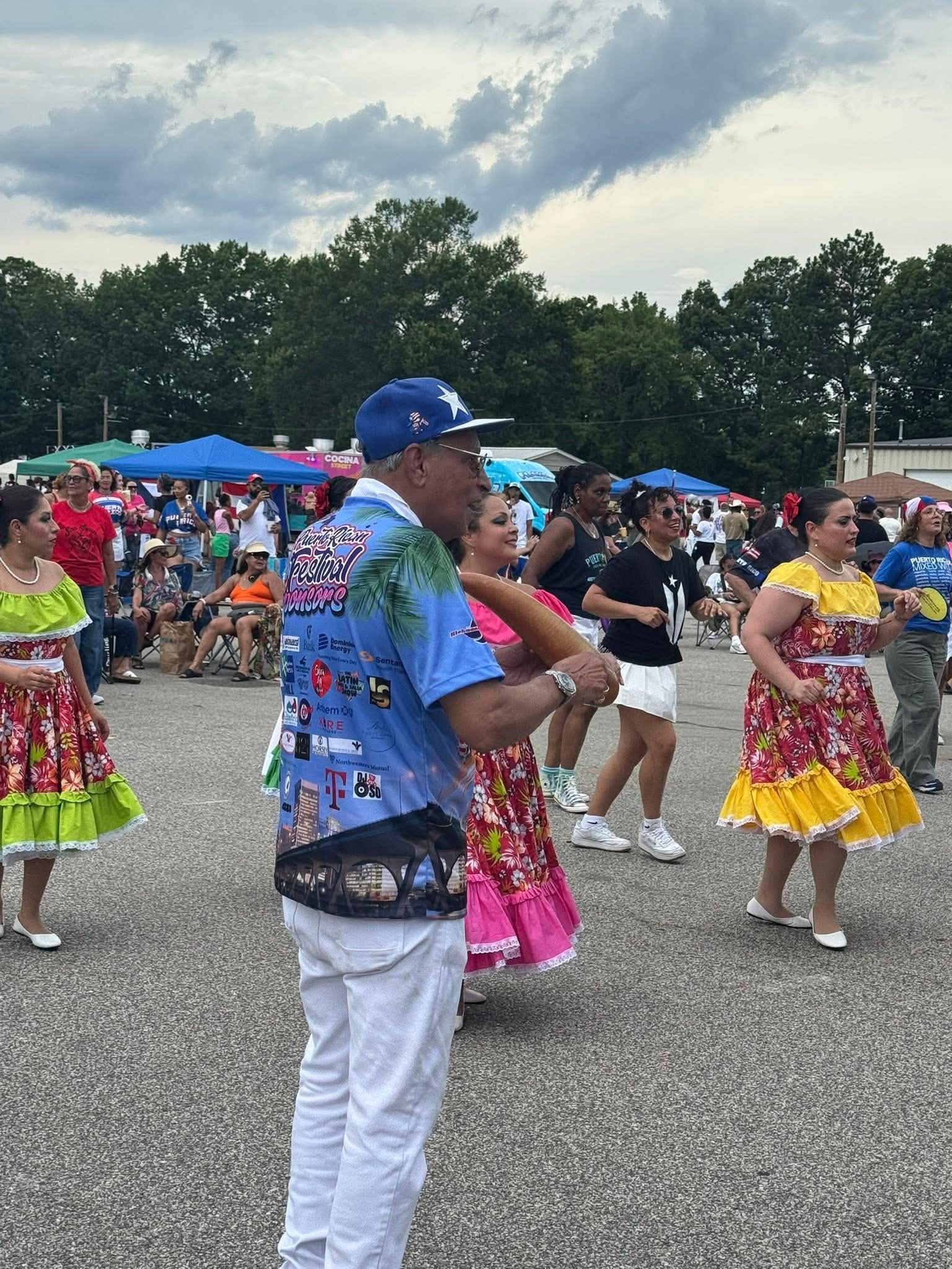 Dancers in bright traditional dresses move through the crowd at the Puerto Rican Festival.